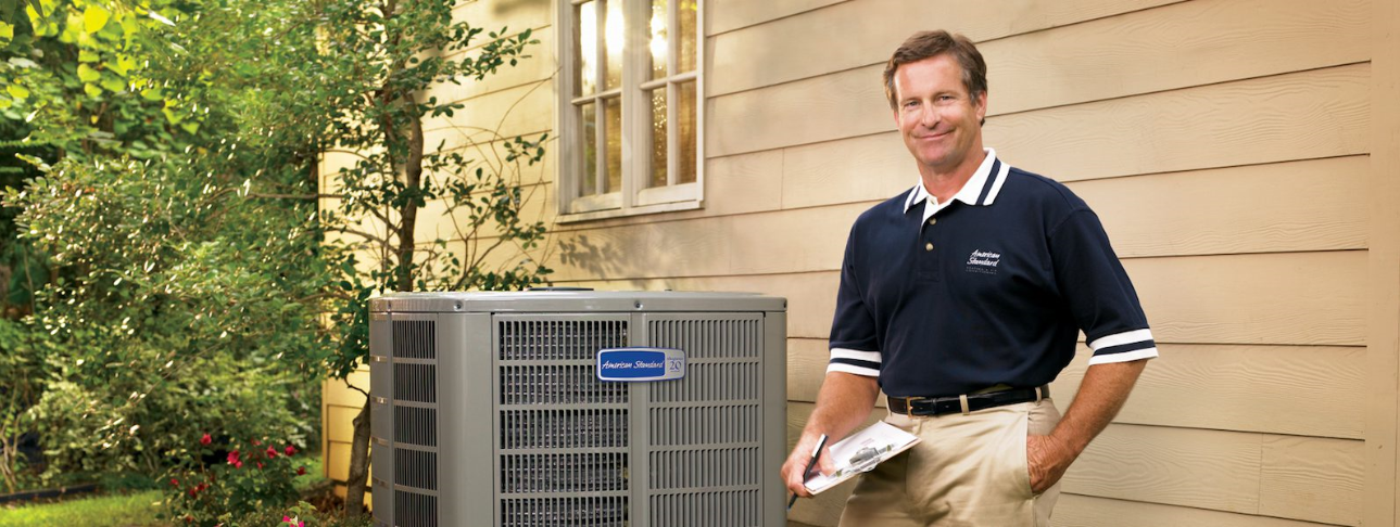 Men hold notepad on his hand and stand near American Standard Air Conditioning