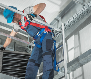 Warehouse Commercial Building Heating Device Servicing by Caucasian Technician on Scaffolding. HVAC Job. Warehouse Commercial Building Heating Device Servicing by Caucasian Technician on Scaffolding. HVAC Job.